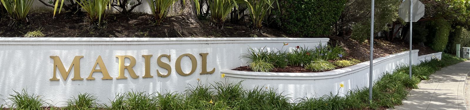 The Marisol entrance monument, gold lettering on a white wall.
