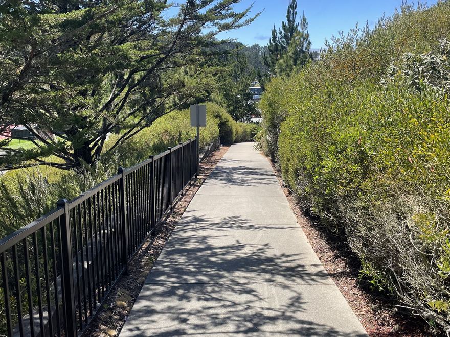 A fenced walking path through the landscaped grounds at Marisol.